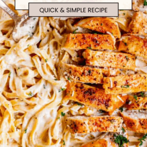 A skillet filled with creamy chicken alfredo fettuccine, topped with sliced, seasoned grilled chicken breast and garnished with parsley. Text overlay reads Quick Chicken Alfredo.