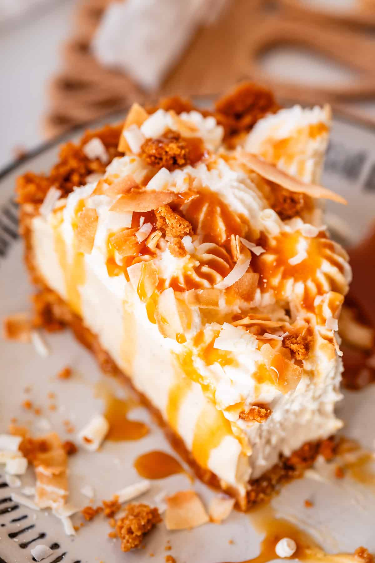 slice of coconut cream pie with white chocolate garnish and caramel drizzle.