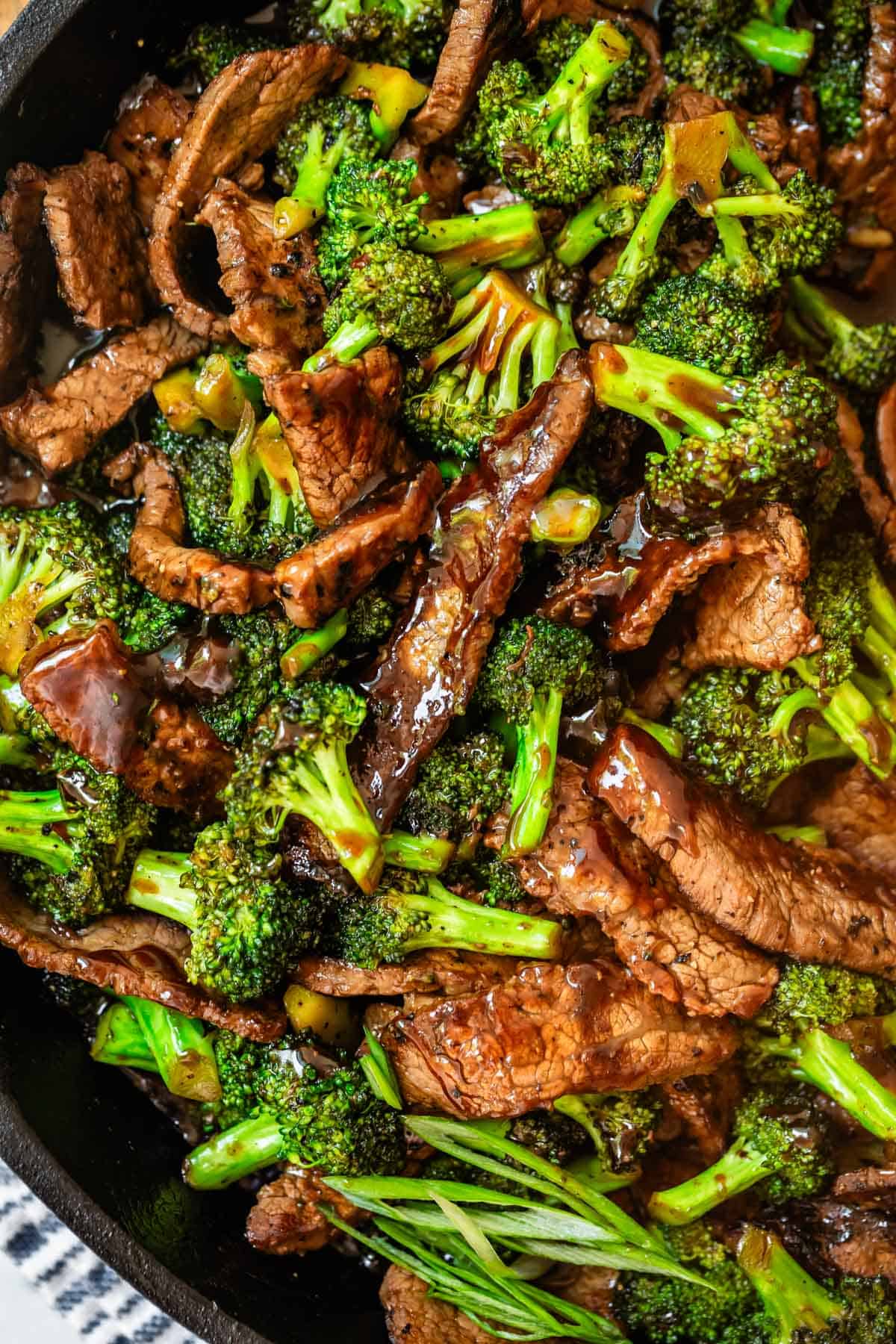 overhead shot of beef with broccoli in a black cast iron skillet.