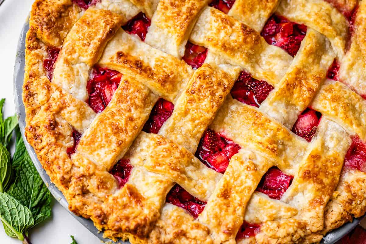 a perfectly baked strawberry rhubarb pie with a perfectly cooked lattice crust.