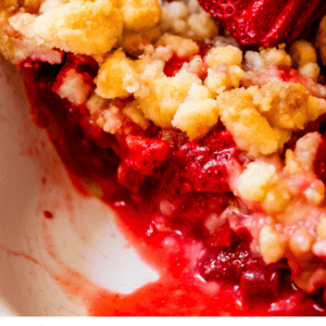 pinterest image of a slice of crumble topped pie with text "strawberry rhubarb pie look at that crumble".