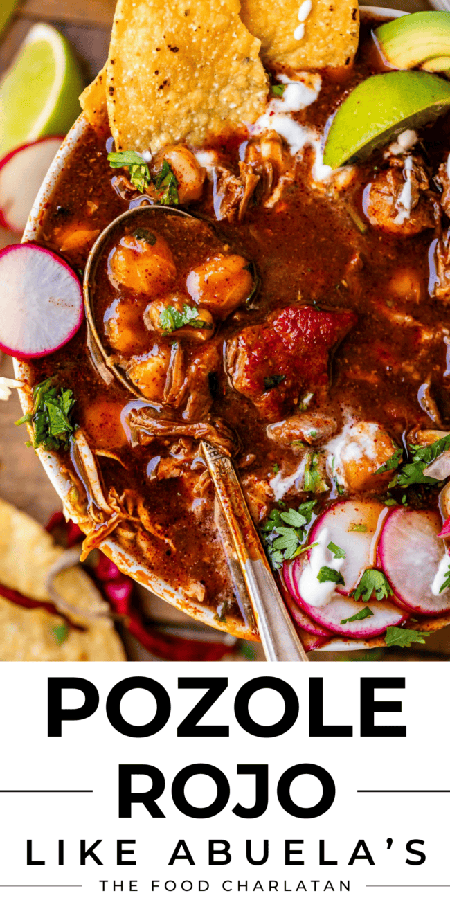 pozole rojo in a white bowl with a spoon, limes, chips, and radishes.