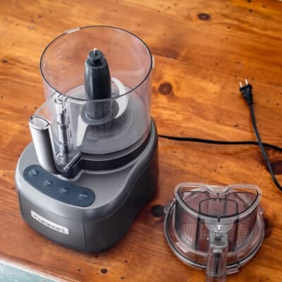 Cuisinart food processor on wooden table.