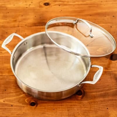 12-inch high sided stainless steel skillet on wooden table.