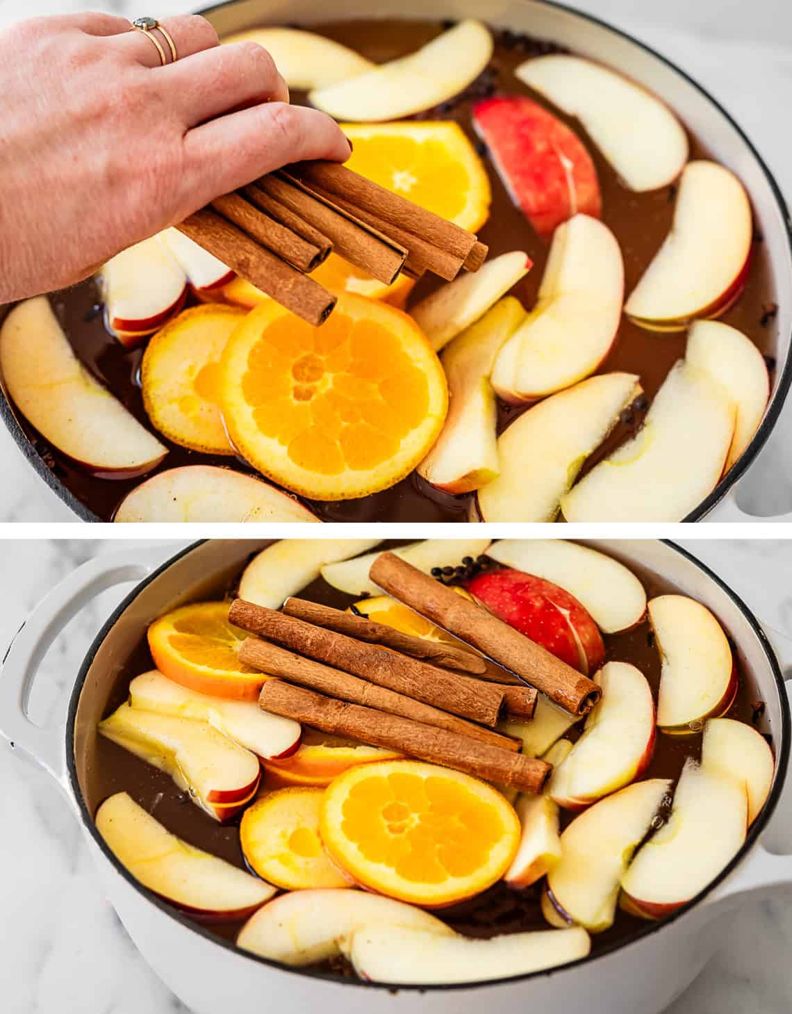 hand adding whole cinnamon sticks into pot filled with wassail ingredients.