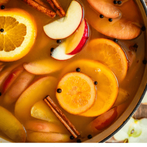 pinterest image of wassail in a pot with text "perfectly spiced homemade wassail".