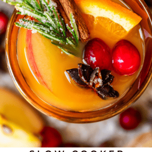 pinterest overhead image of spiced drink in a gold glass with cranberry, orange, cinnamon.
