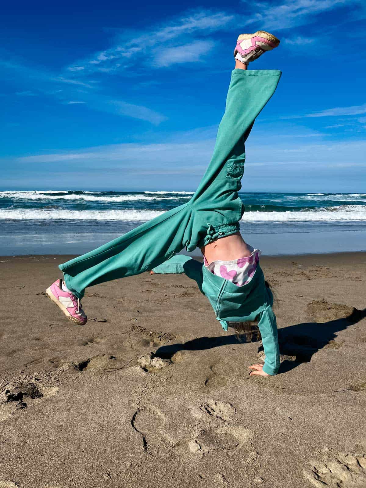 girl doing a cartwheel on the beach.