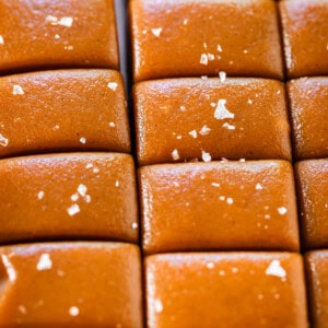 Soft caramel candy still in a slab, but with slices cut to separate into pieces.