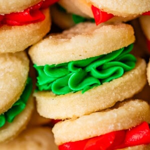close up showing decorative piping of christmas colored frosting in wafer cookies.