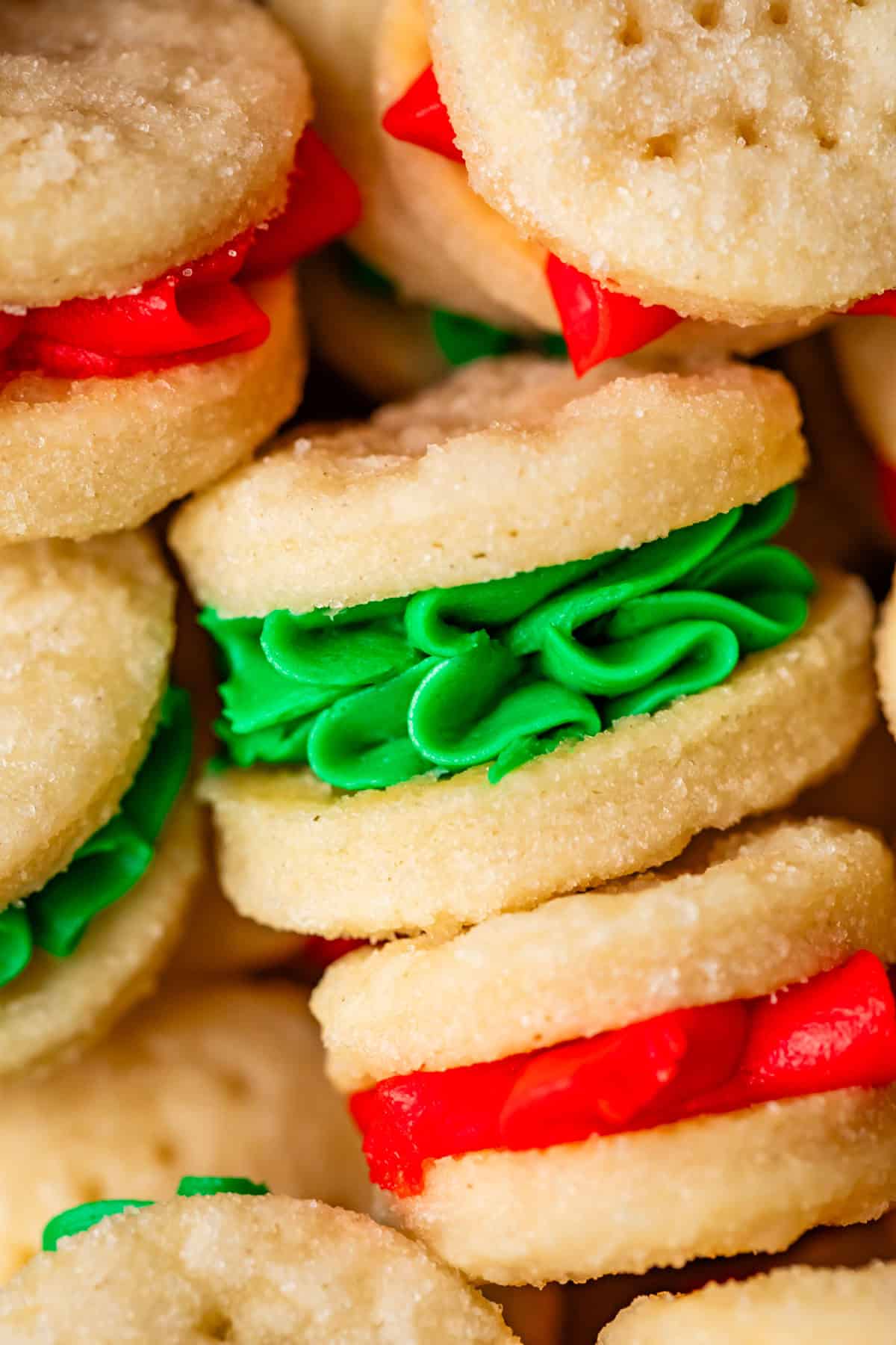close up showing decorative piping of christmas colored frosting in wafer cookies.