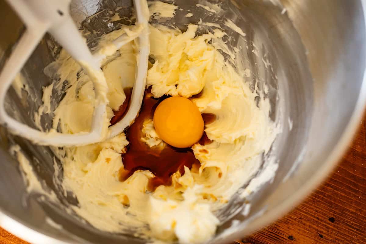 vanilla, egg yolk, and butter in metal stand mixer bowl.