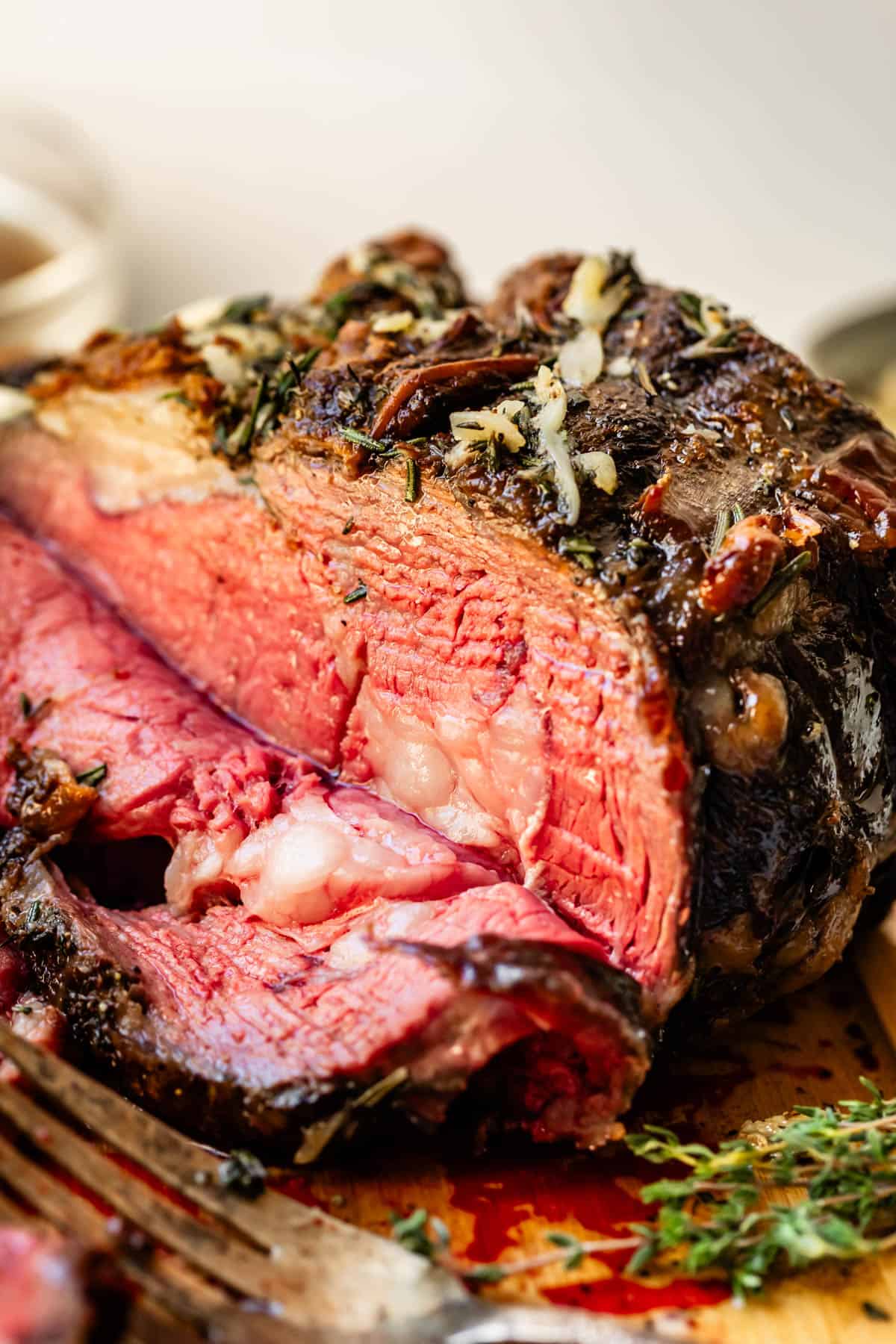Prime rib roast with slice cut and well cooked crusty outer layer.