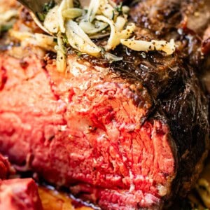 Cross cut of prime rib roasted in the oven with garlic and butter drizzled over.