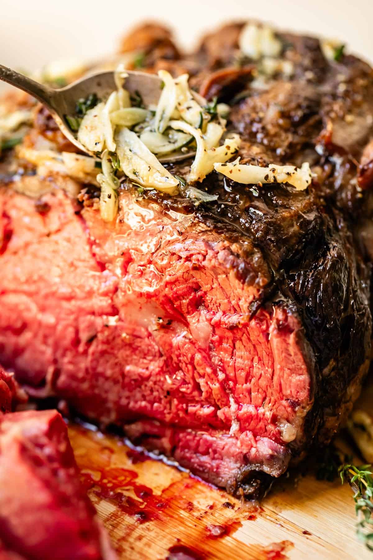Cross cut of prime rib roasted in the oven with garlic and butter drizzled over.