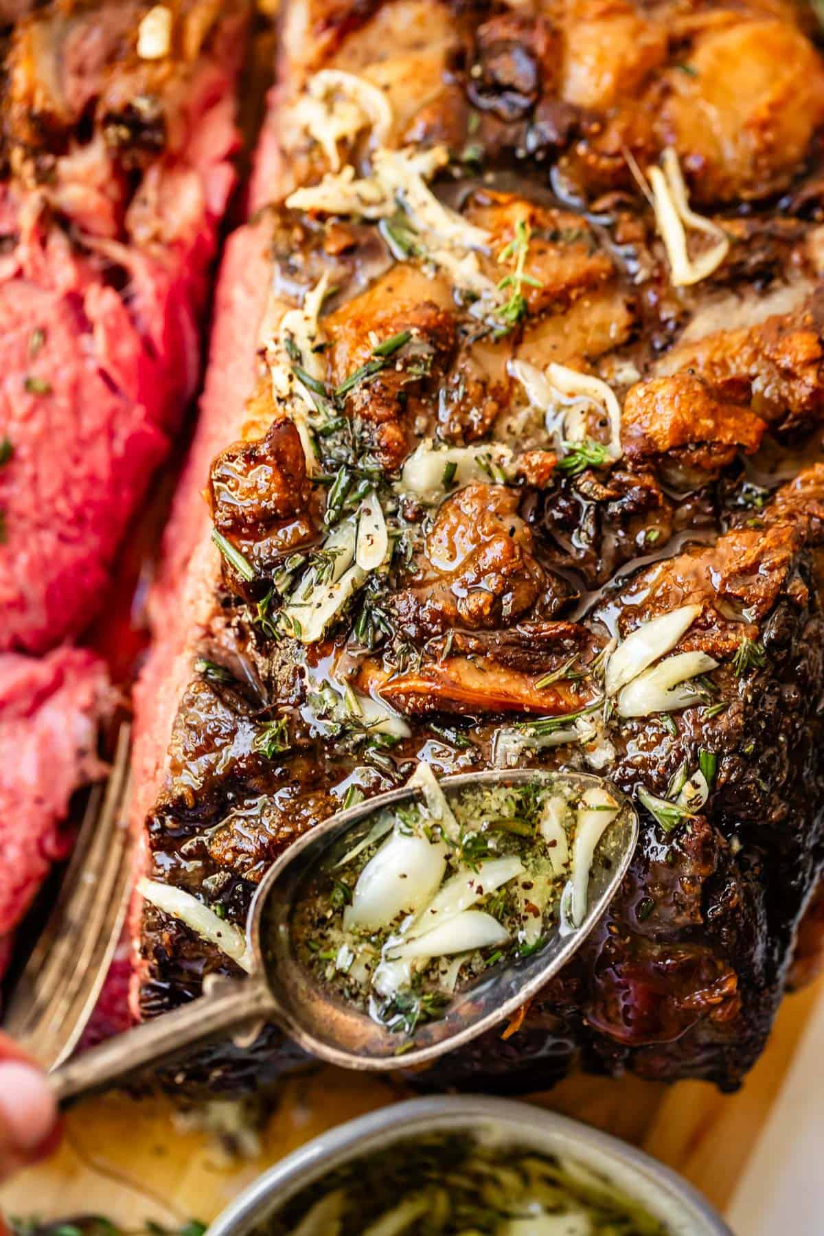 Spooning garlic and herb butter over beef roast.