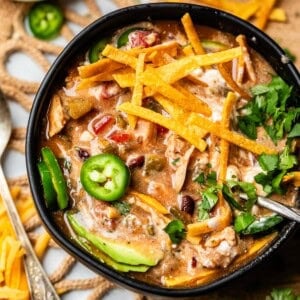 a bowl of tortilla chicken soup looking more creamy because of sour cream mixed in.