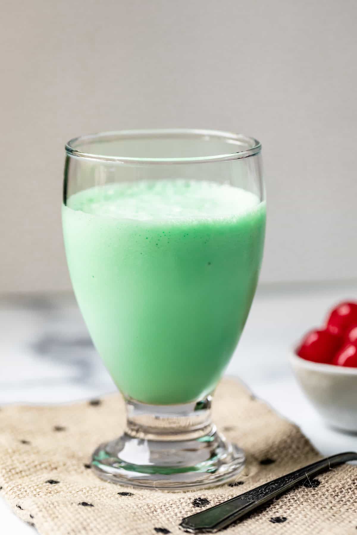 simple glass on a cloth napkin, filled with shamrock shake.