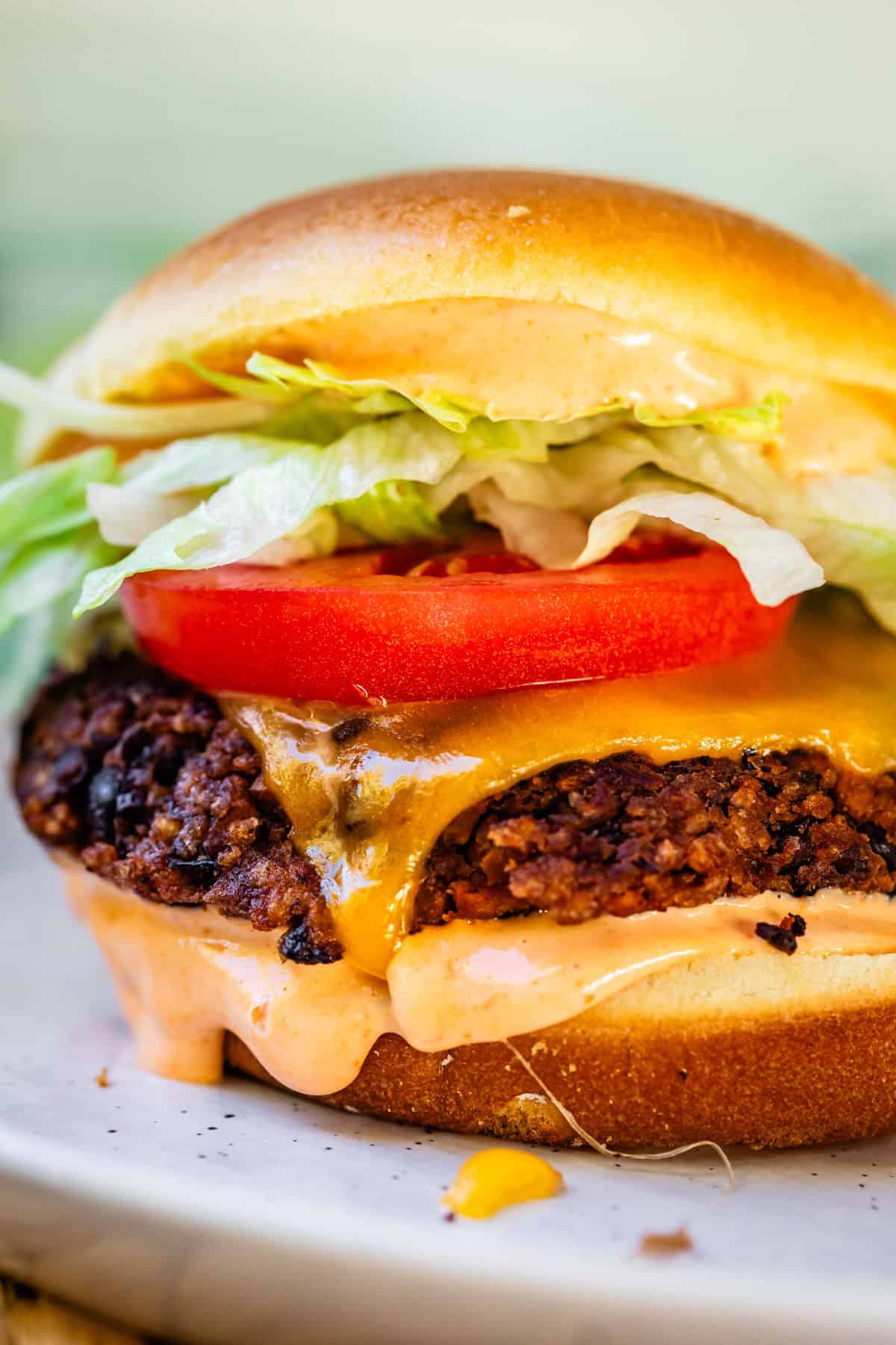 a black bean burger with veggies, cheese, and sriracha mayo.