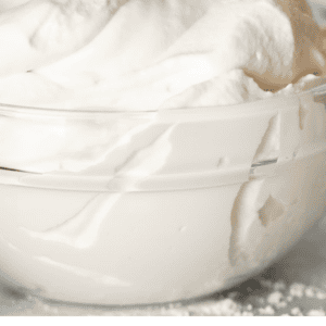 pinterest image of bowl of whipped cream with text "how to make whipped cream".