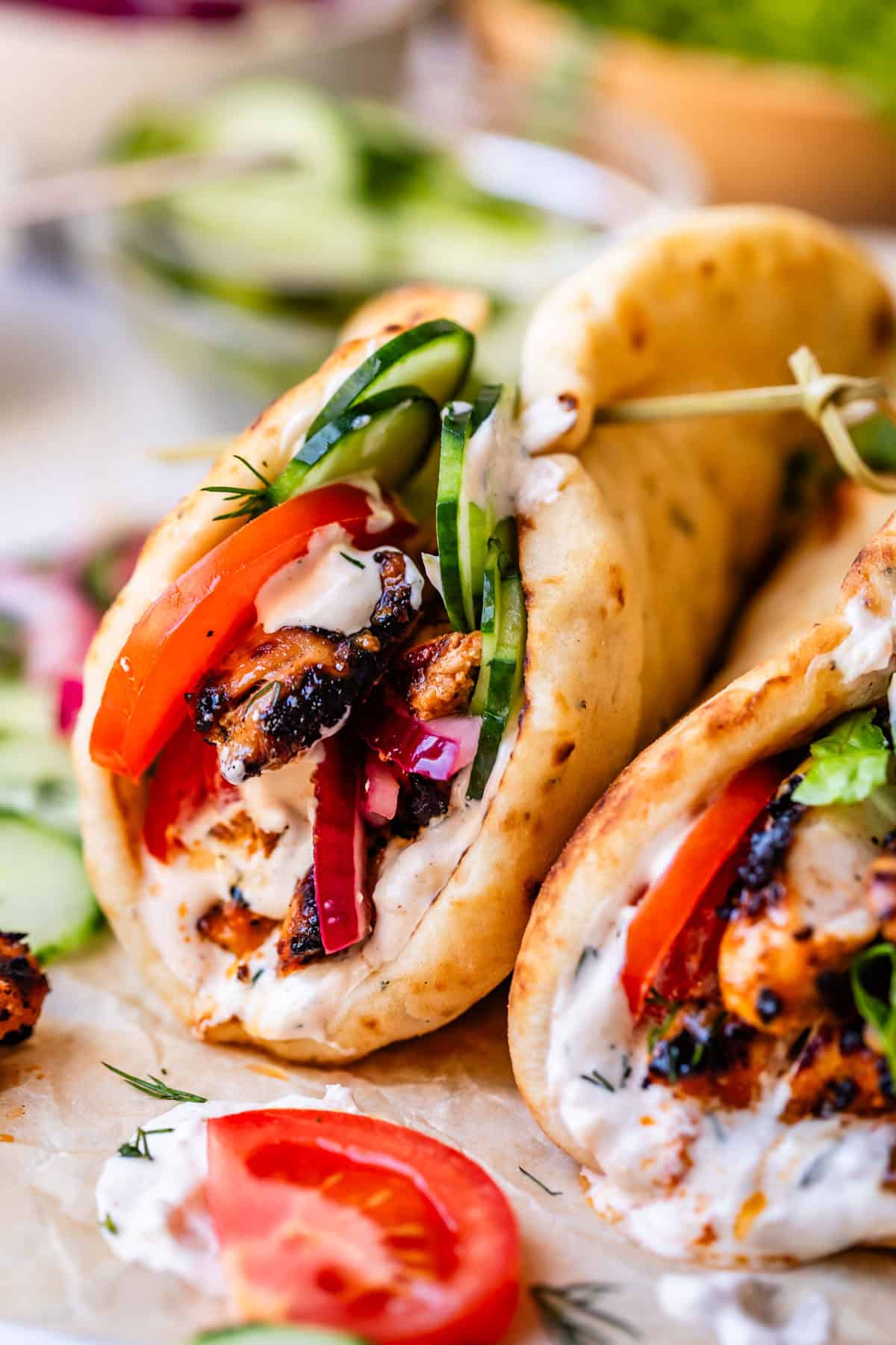 side of two chicken shawarma naan with toothpicks holding the tops together.