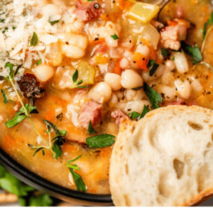 pinterest image of bowl of soup with text "homemade ham bean soup".