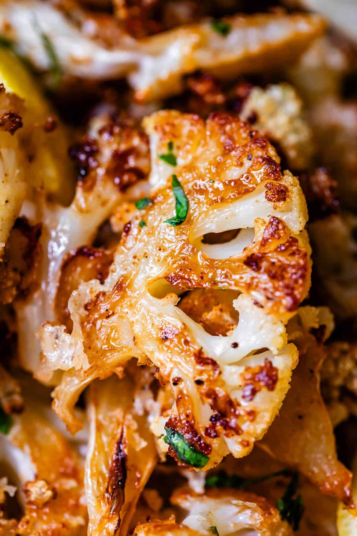 goldeny roasted cauliflower floret with crisp edges and parsley garnish.
