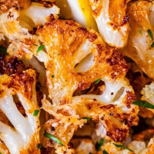 perfectly golden brown and crispy roasted cauliflower with parsley garnish.