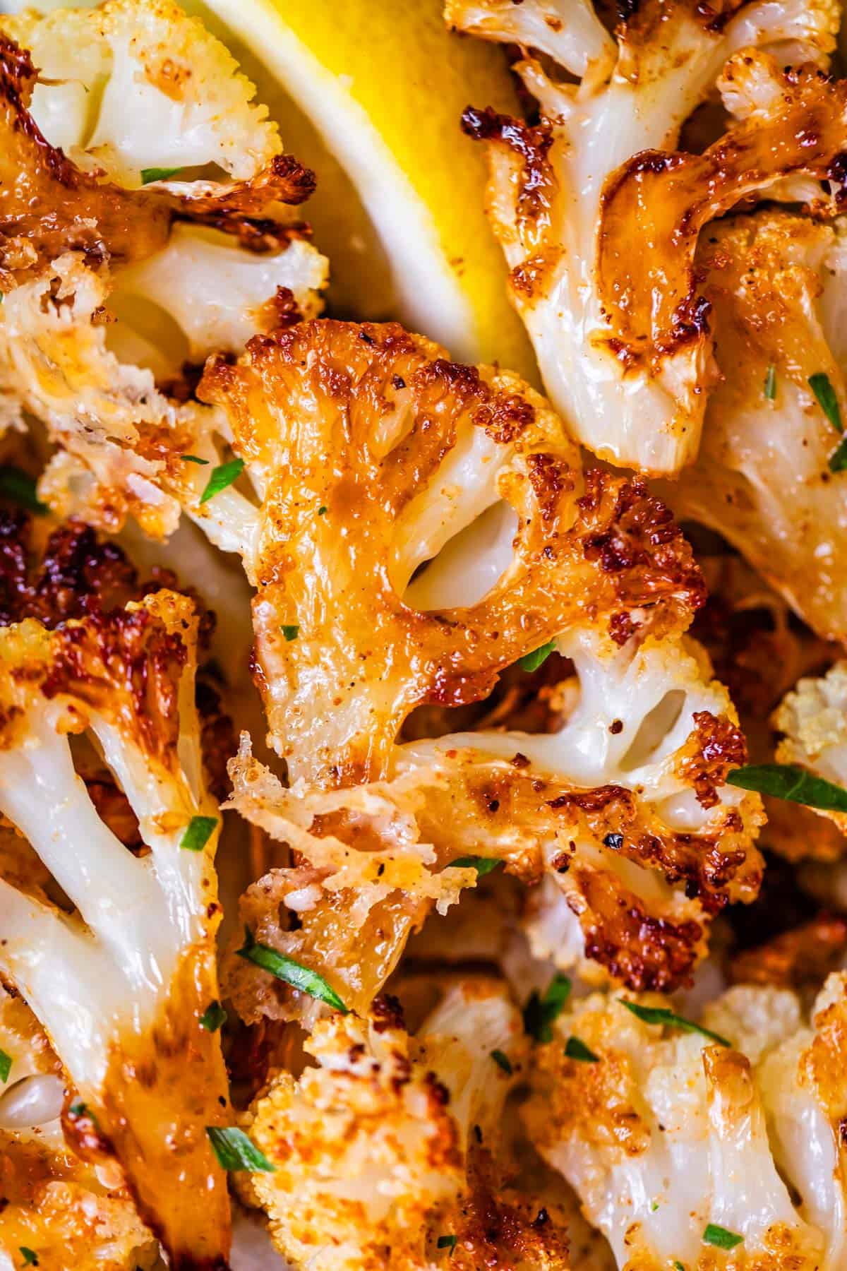 perfectly golden brown and crispy roasted cauliflower with parsley garnish.
