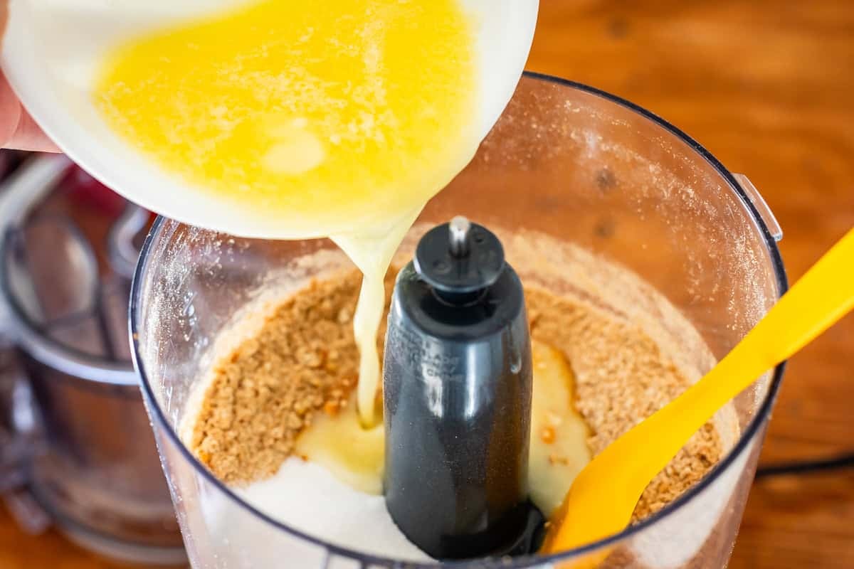 pouring butter into crushed pretzels, crushed pretzel butter mixture in a food processor.