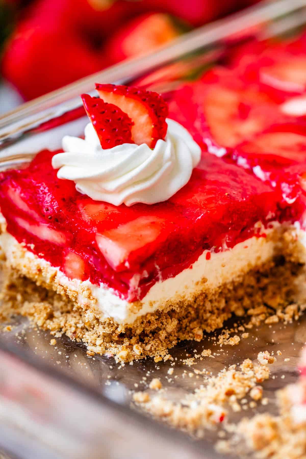 a slice of strawberry jello pretzel salad in a pan.