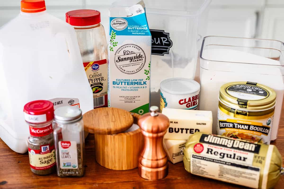 ingredients for biscuits and gravy like sausage, flour, milk, butter, and seasonings.