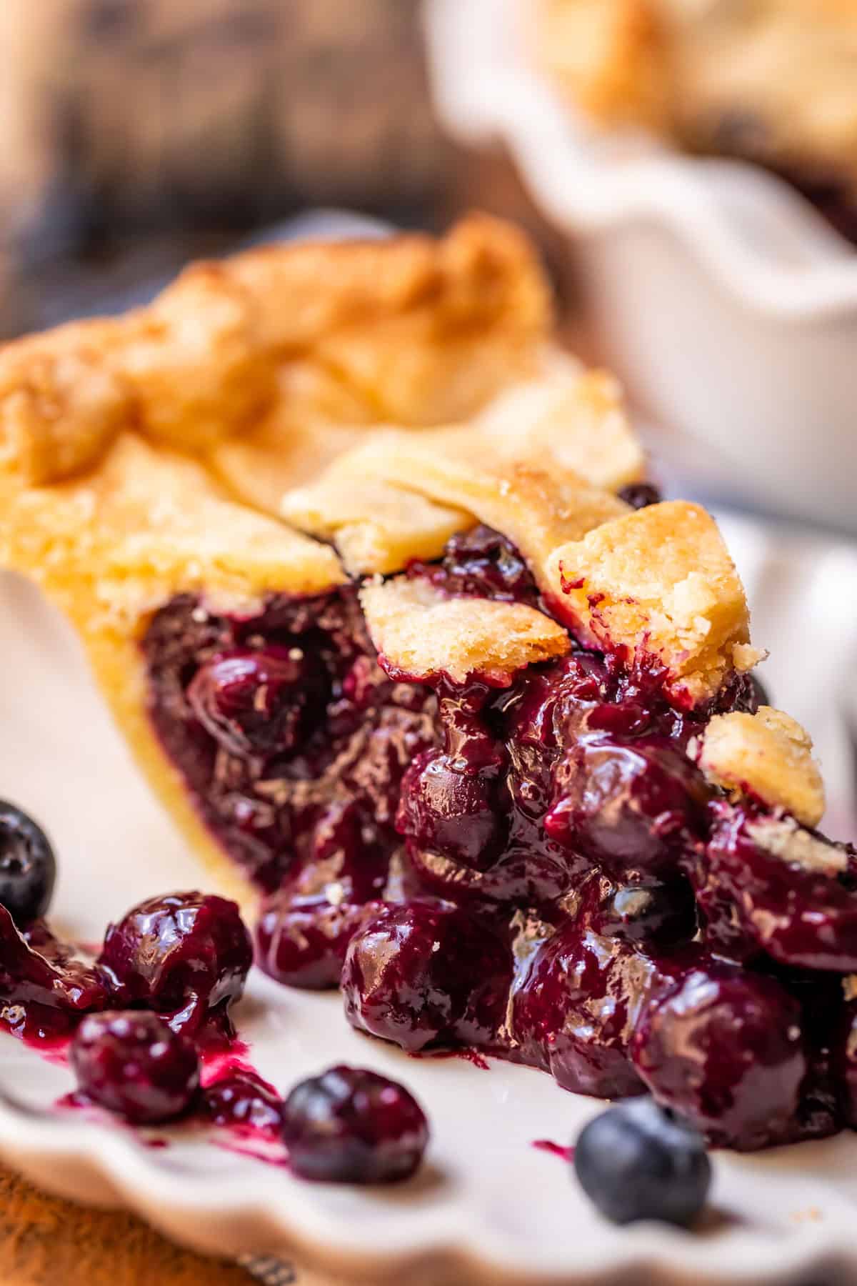 piece of blueberry pie with lattice crust on a white plate