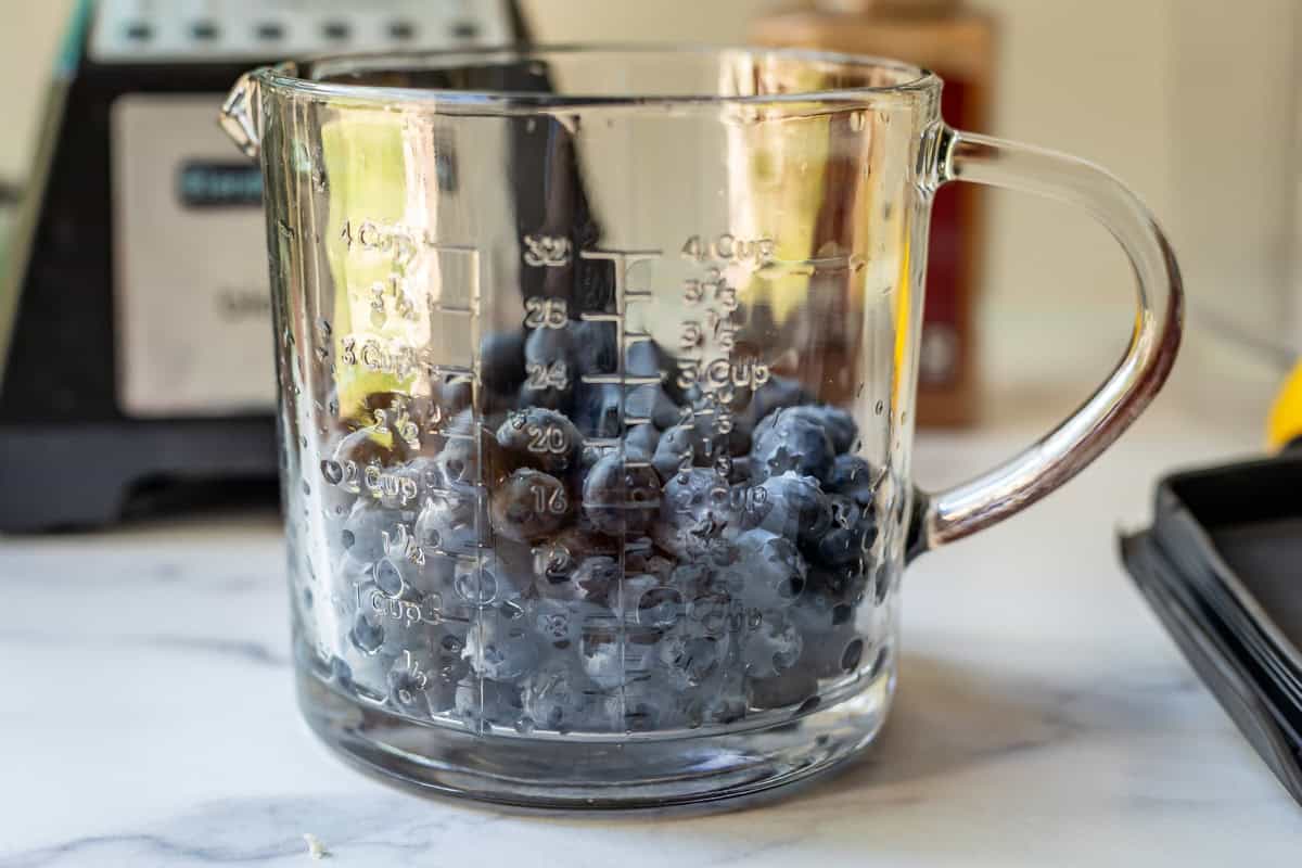 2 cups of fresh blueberries in a glass measuring cup.