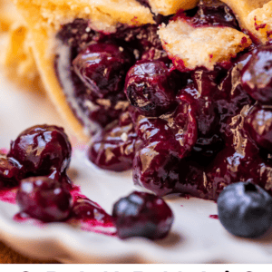 slice of juicy blueberry pie with ice cream on top.