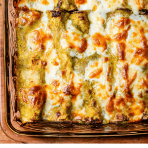 pinterest image of enchiladas in a casserole dish with text "your new favorite chicken enchiladas".