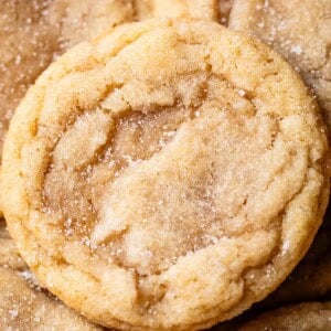 close up of a no roll sugar cookie sitting on top of a loose pile of other sugar cookies.