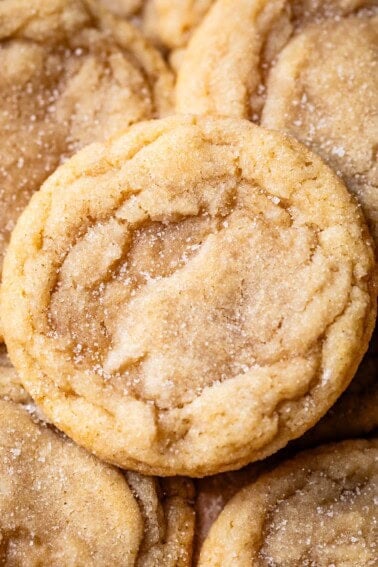 close up of a no roll sugar cookie sitting on top of a loose pile of other sugar cookies.