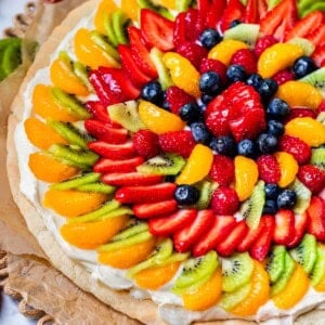 whole fruit pizza beautifully topped with oranges, kiwi, strawberries, blueberries, and more.
