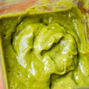 a blender filled nearly to the top with rich and thick green enchilada sauce.