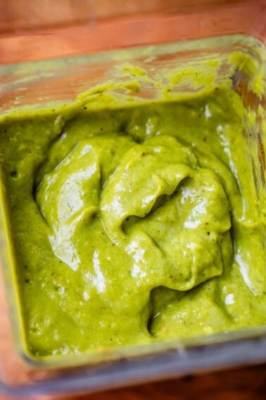 a blender filled nearly to the top with rich and thick green enchilada sauce.