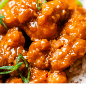 pinterest image of orange chicken and rice with text "better than takeout orange chicken".