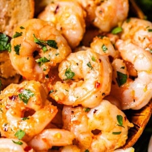 shrimp in garlic butter sauce with a lemon wedge.