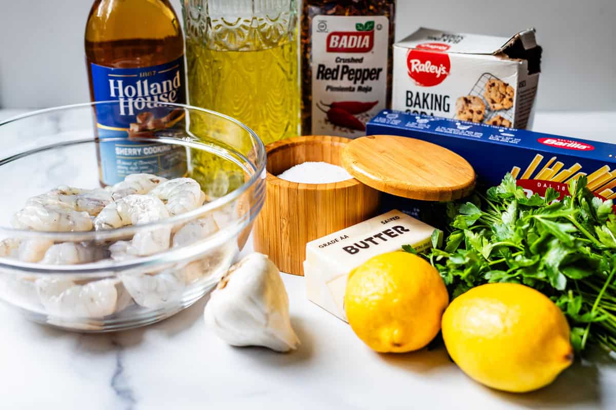 ingredients for shrimp scampi including shrimp, garlic, butter, lemons, and parsley.