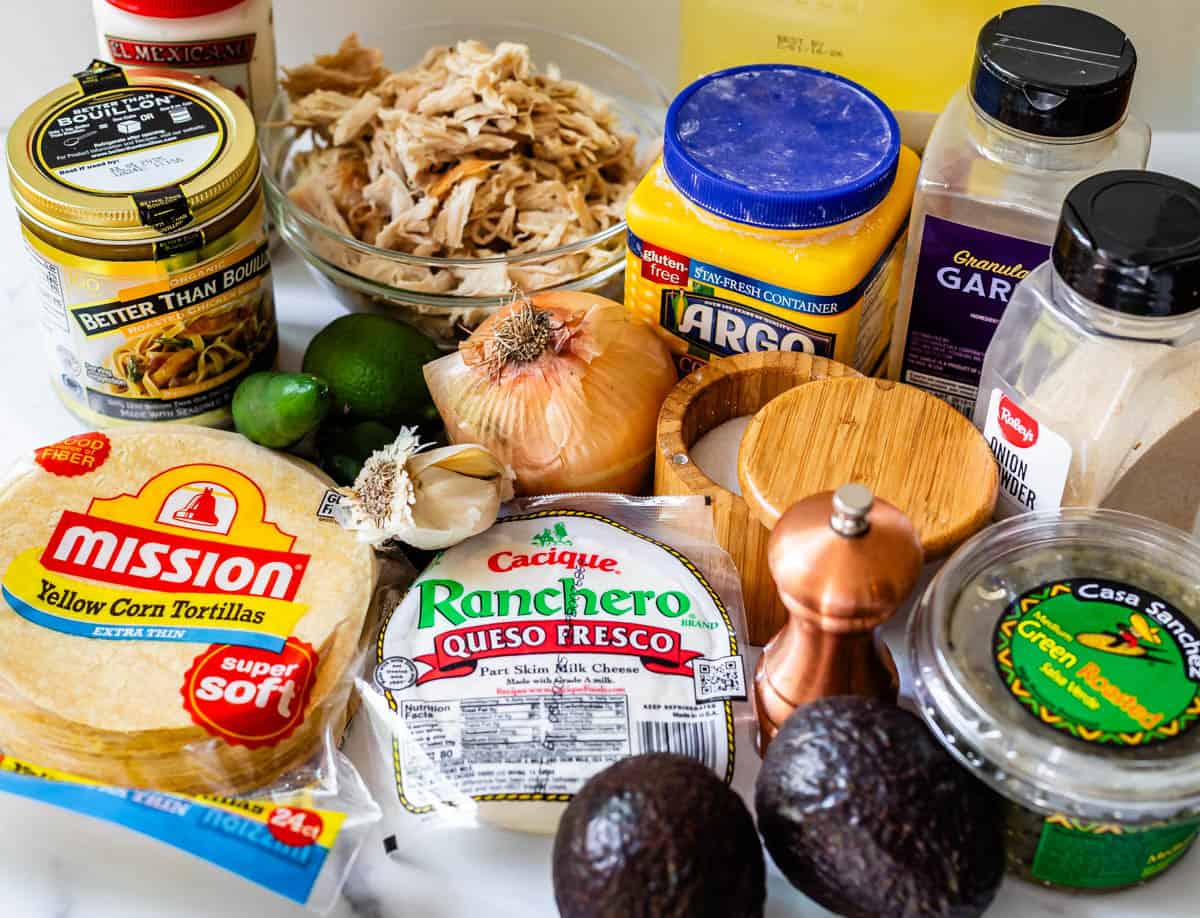 ingredients for chicken flautas like chicken, corn tortillas, onion, salsa verde, and more.