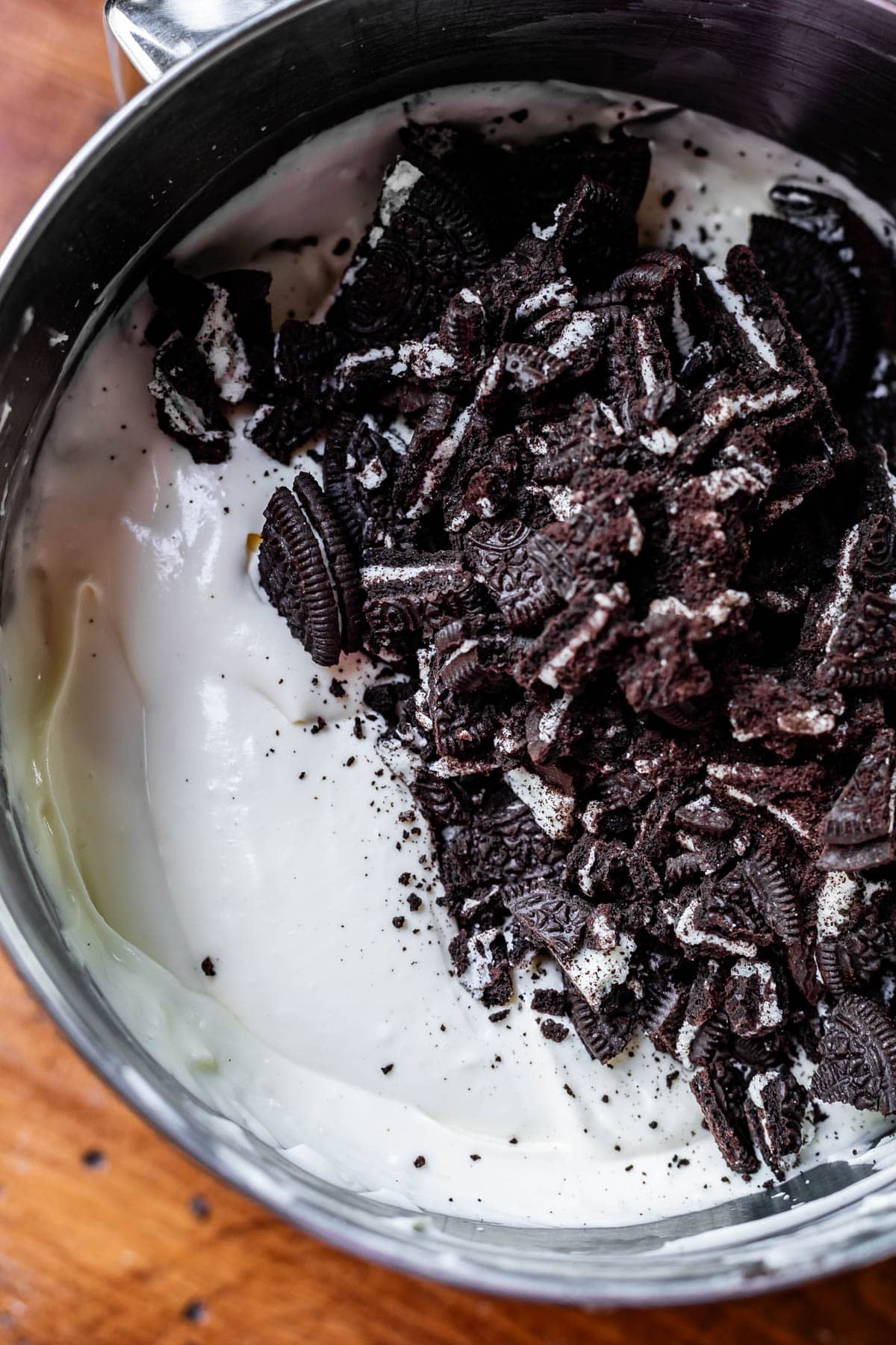 chopped oreos dumped into cheesecake batter but not yet mixed in.