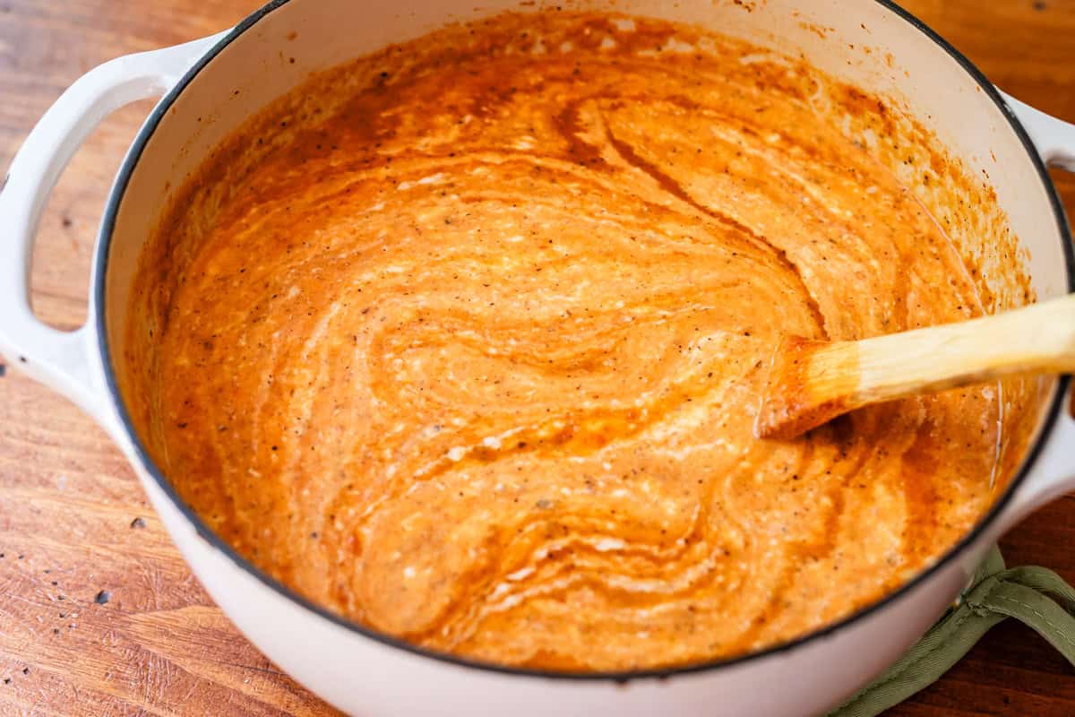 tomato bisque with the white sauce barely mixed in, showing how velvety smooth it is.