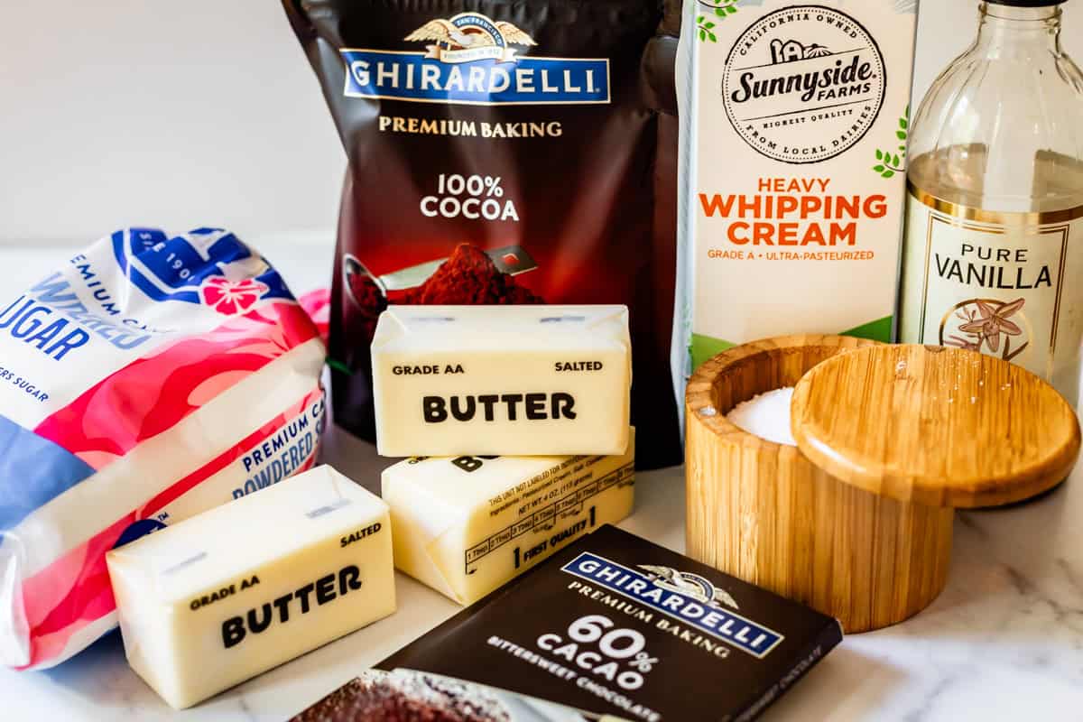 ingredients for chocolate buttercream frosting like butter, chocolate, cream, and more.
