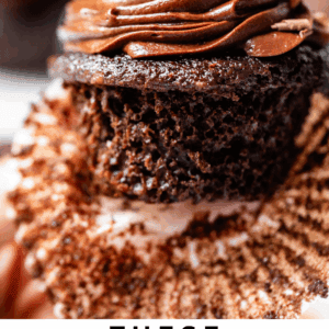 unwrapped chocolate cupcake with chocolate frosting and chocolate shavings.