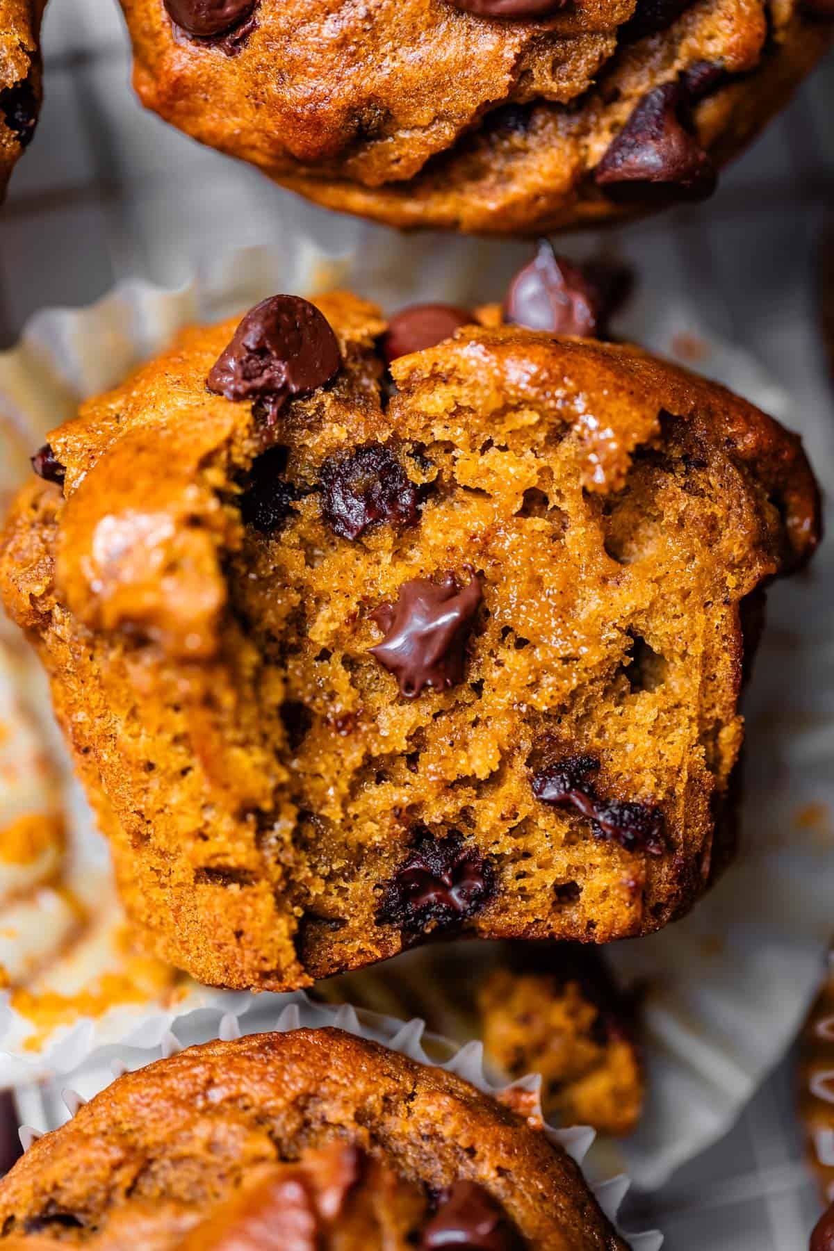 a muffin lying on its side with a bite taken from it, showing all the chocolatey goodness.